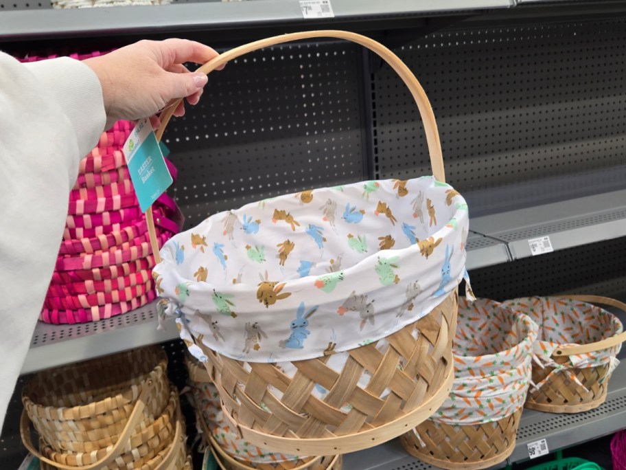 hand holding a woven Easter basket with a white fabric liner that has bunny rabbits on it