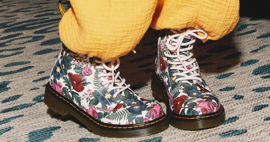 kid wearing yellow pants with floral garden print Dr. Martens boots