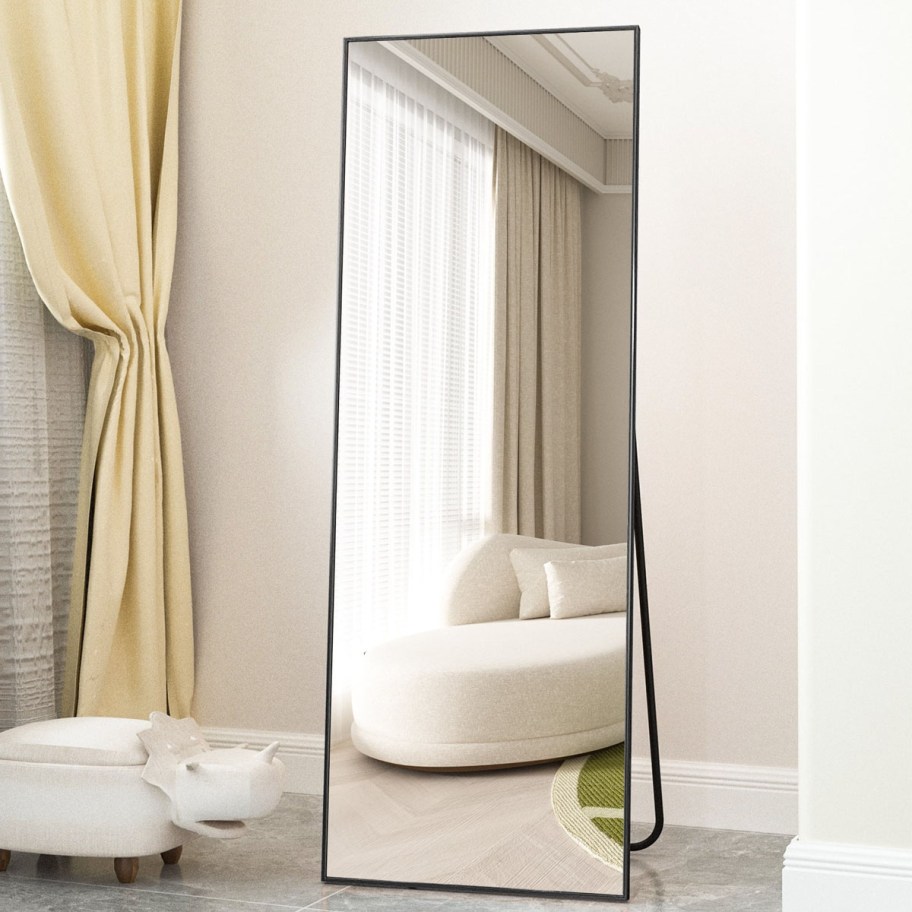 black framed floor length mirror in bedroom