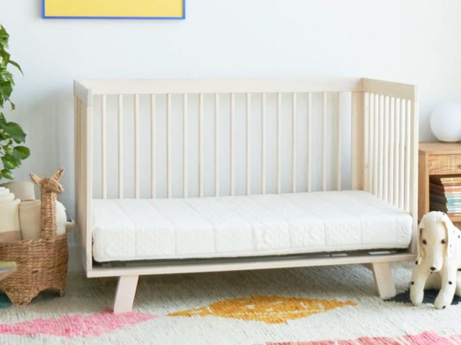 white wood crib with white mattress inside