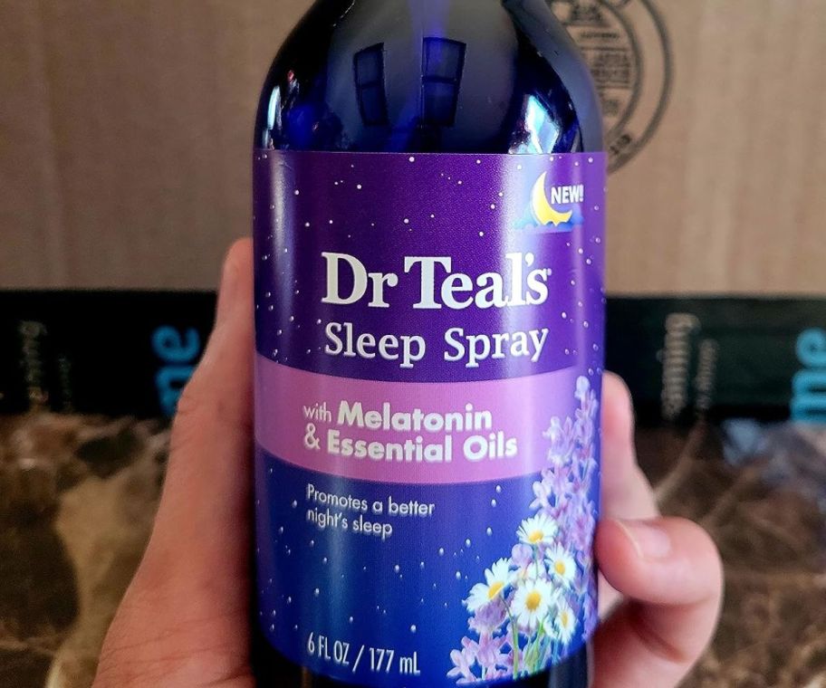 A hand holding Dr Teal's Sleep Spray