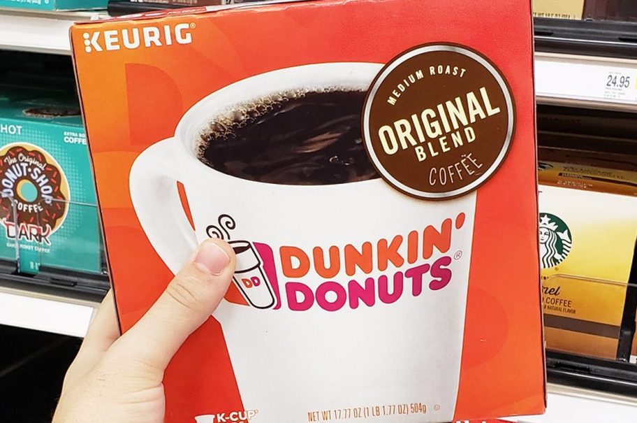 hand holding a large orange box of dunkin k-cups