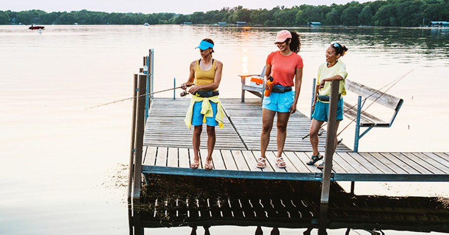 family standing on dock fishing