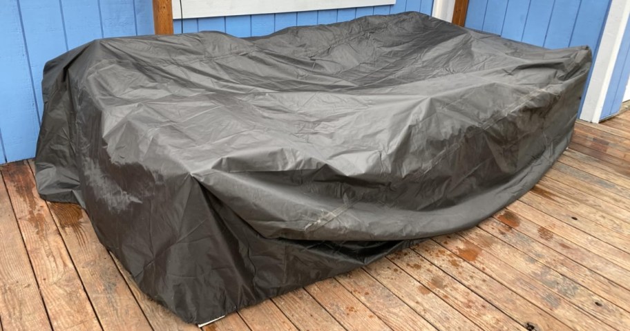 black patio furniture cover over patio furniture on a deck