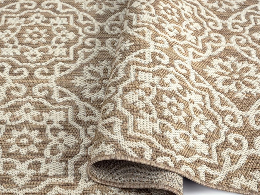 edge of a brown and beige geometric print indoor/outdoor rug