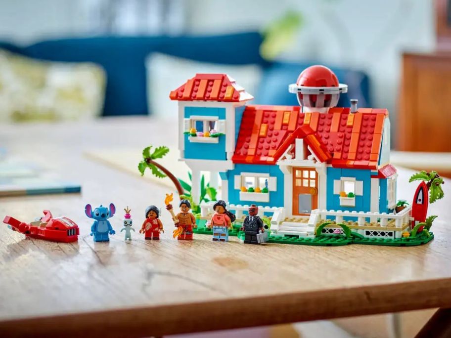 LEGO Disney Lilo & Stitch Beach House on a table with minifigures lined up next to it