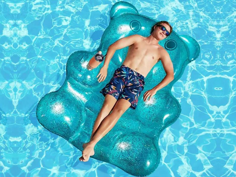 Man laying on a giant teal bear Member's Mark pool float in a pool