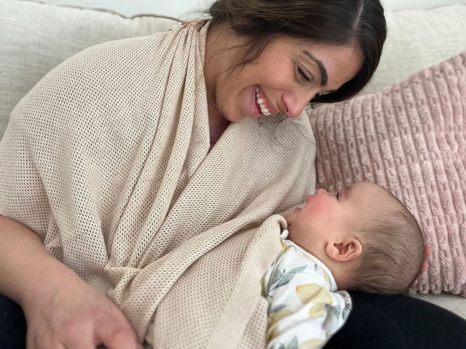 Woman wearing a Quince Nursing Shawl smiling at her baby while the baby smiles back