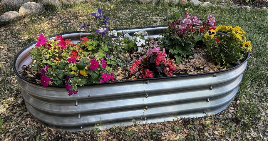 metal raised garden bed full of flowers in yard