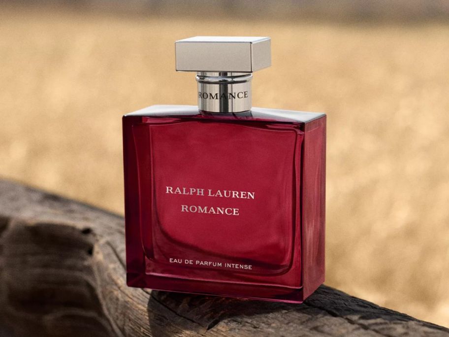 A bottle of aRalph Lauren Romance Intense EDP 3.4oz on a fence