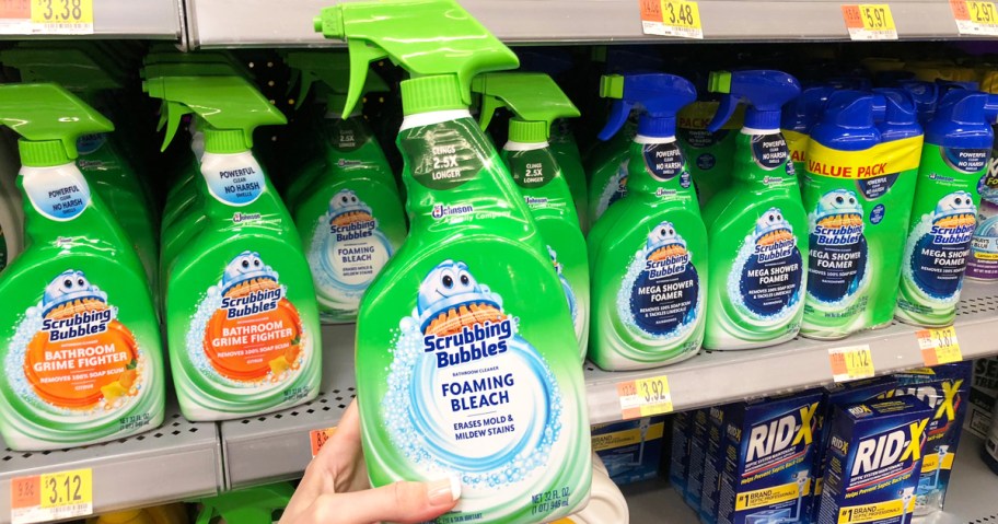 hand holding up a green bottle of Scrubbing Bubbles Foaming Bleach Spray in store