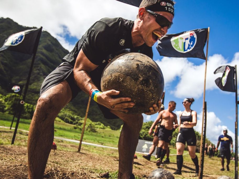 Man holding a medicine ball during a Spartan race