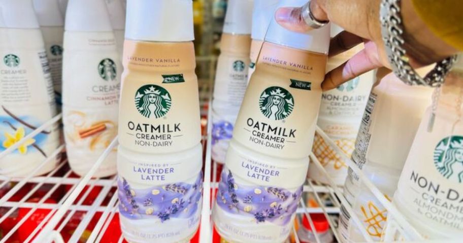 A person holding a Starbucks Oatmilk Lavender Latte Creamer