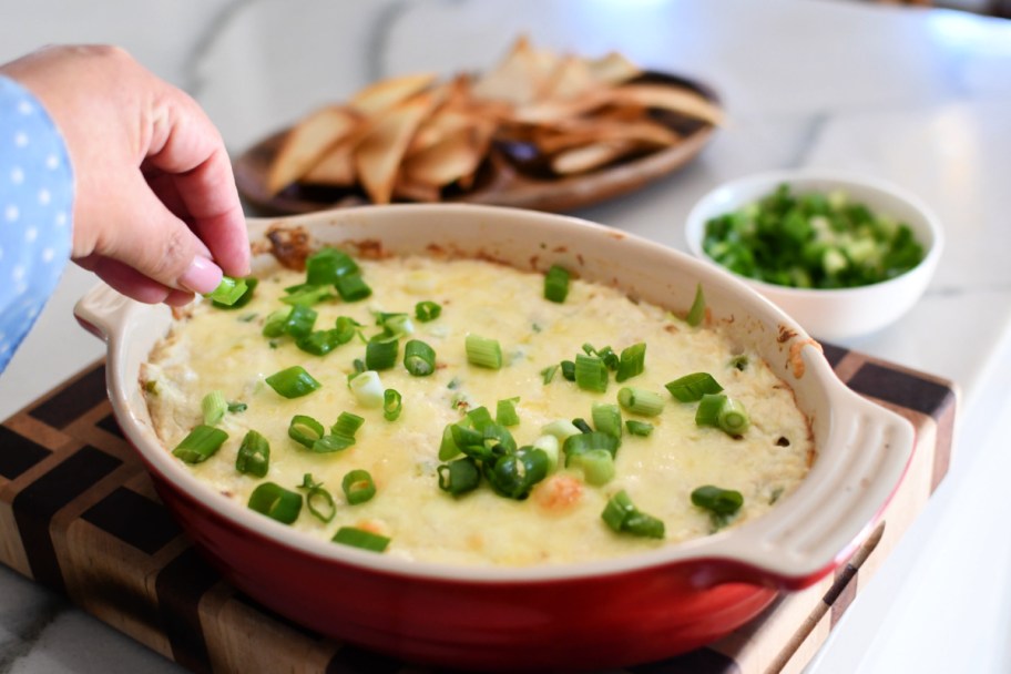 adding sliced green onion to crab dip