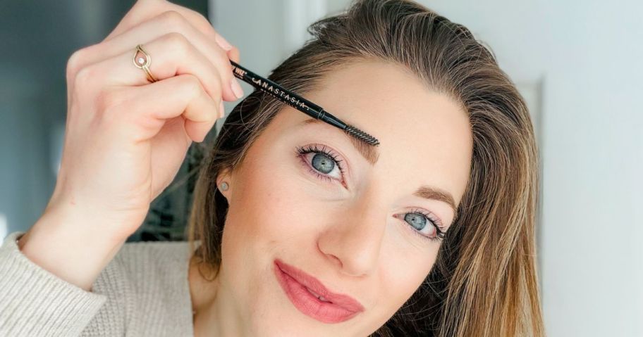 woman applying anastasia brow pencil to her eyebrow