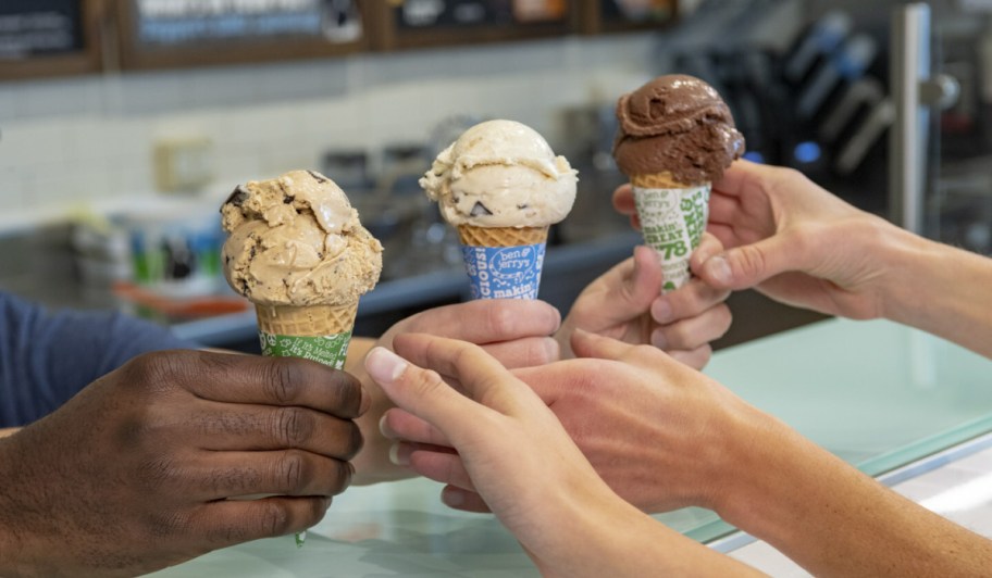 hands passing ben and jerrys ice cream cones to other hands