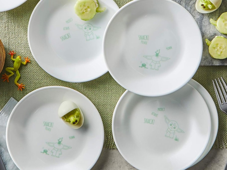 4 white disney corelle plates with star wars characters on them on table