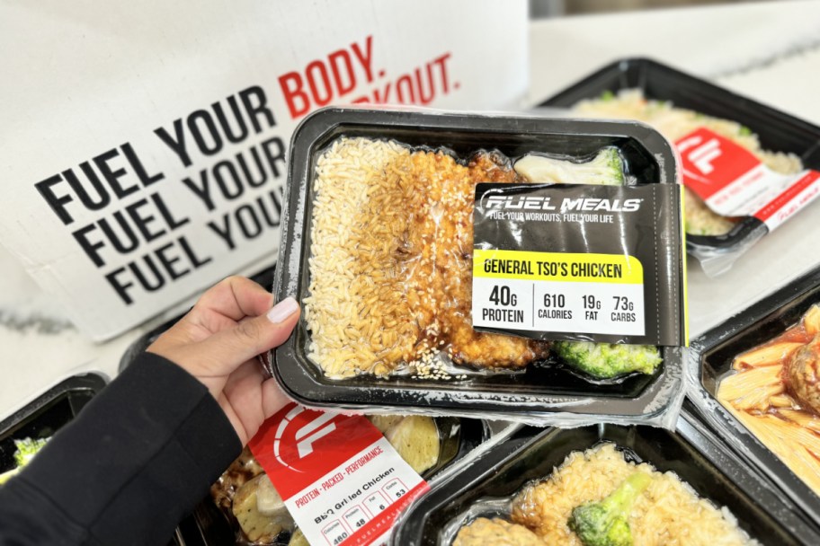 hand holding prepared meal above other meals