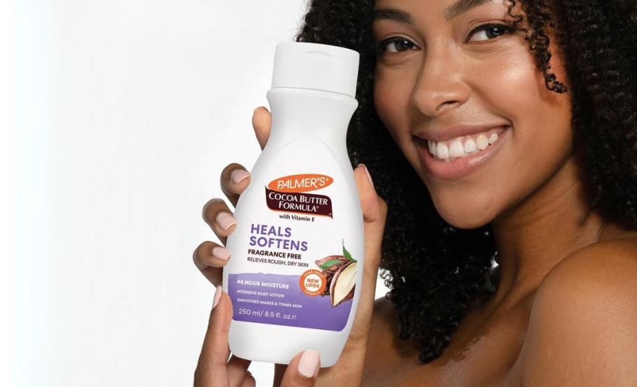 a woman shown holding a bottle of palmers cocoa butter lotion