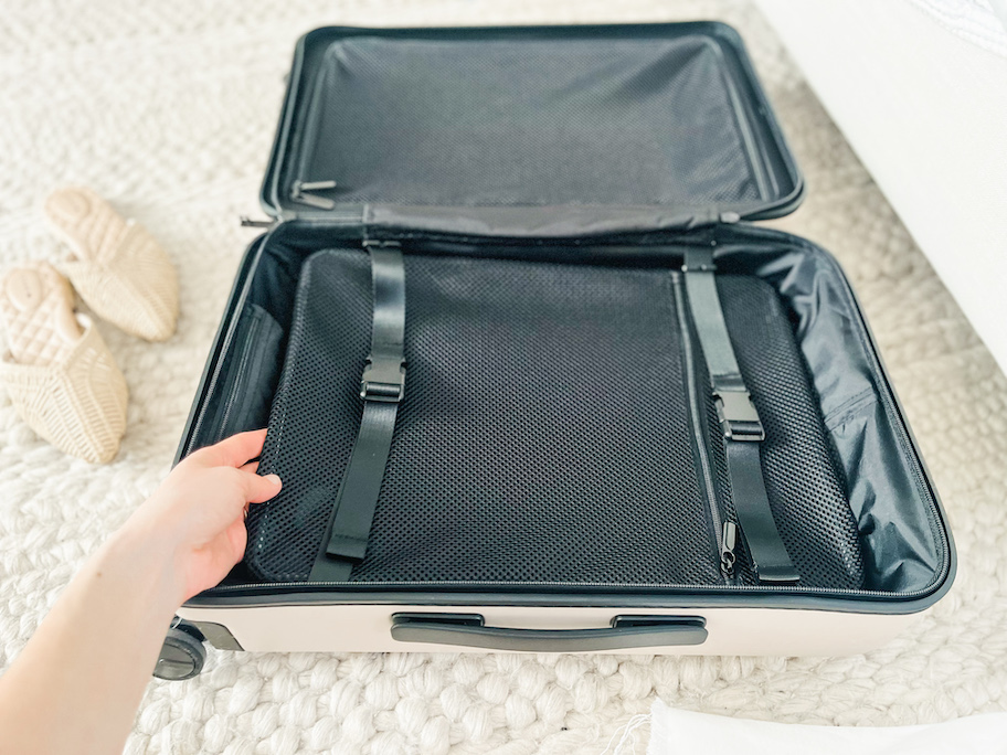 hand holding inside of quince luggage 