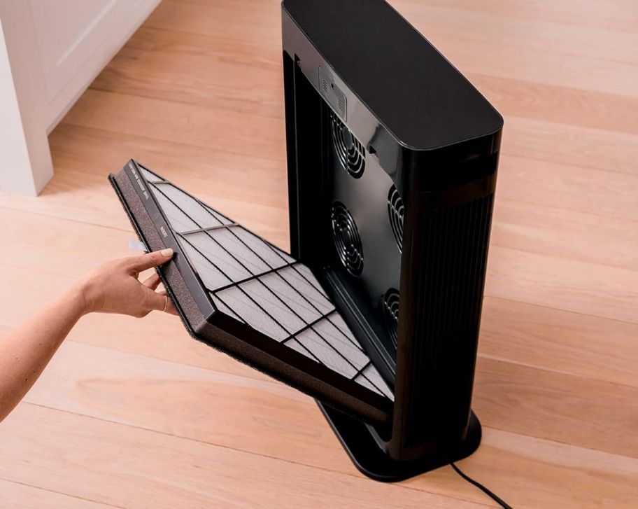 a womans hand opening the filter onlinepartment of a shark air purifier