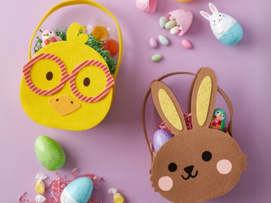 a yellow chick and a brown bunny shaped Easter baskets laying on a purple background with eggs around them