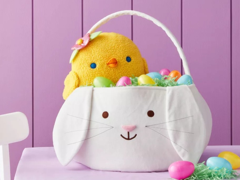 a large white bunny shaped easter basket fill a plush chick and plastic easter eggs in it