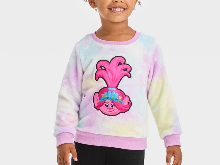 girl wearing tie dye trolls sweater with black pants