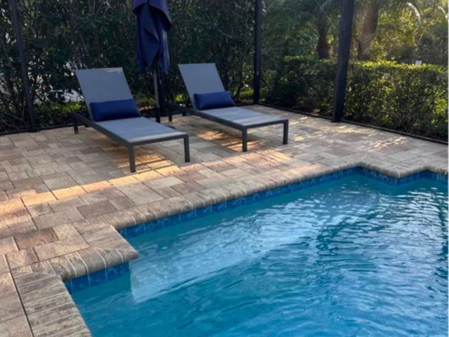 2 blue pillows on lounge chairs by pool