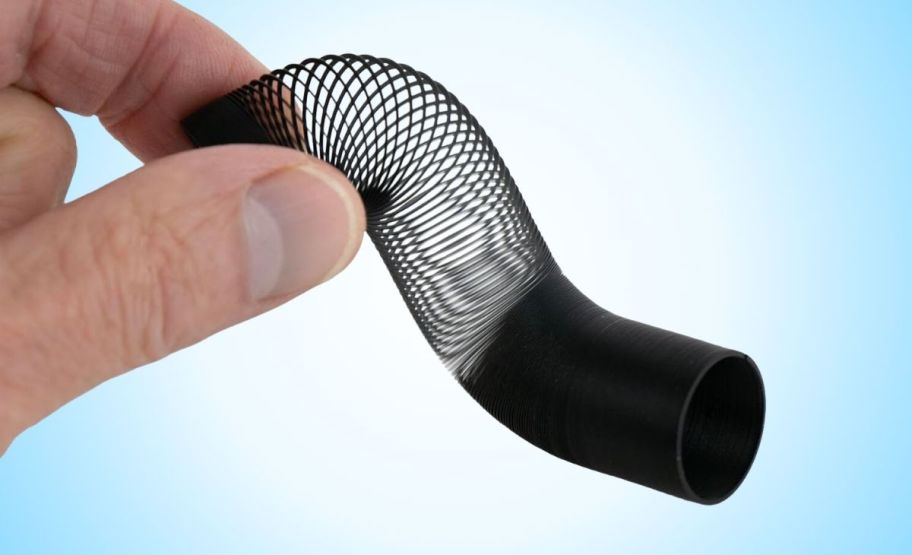 a hand holding the Worlds smallest slinky in black.