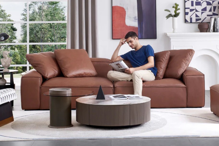 man reading on brown leather couch