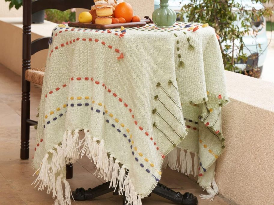 Amélie Home Boho Throw Blanket Green on a table