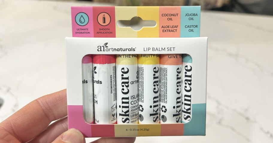 hand holding up a boxed set of ArtNaturals lip balms