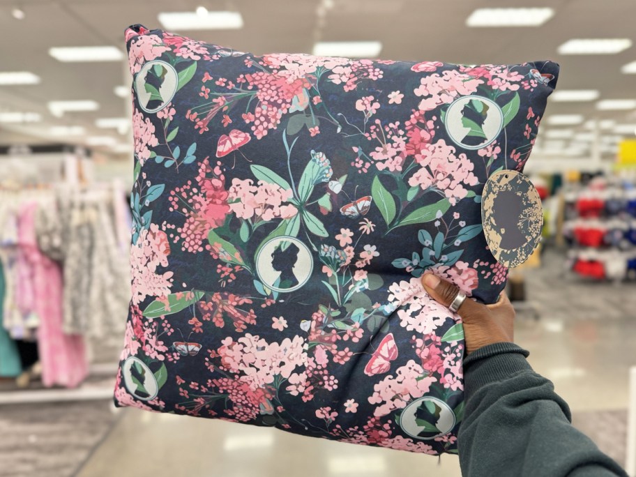 hand holding up a blue and pink floral print throw pillow