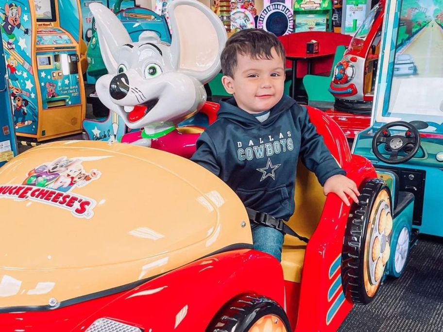 Little boy in a chuck E. cheese amusement car ride