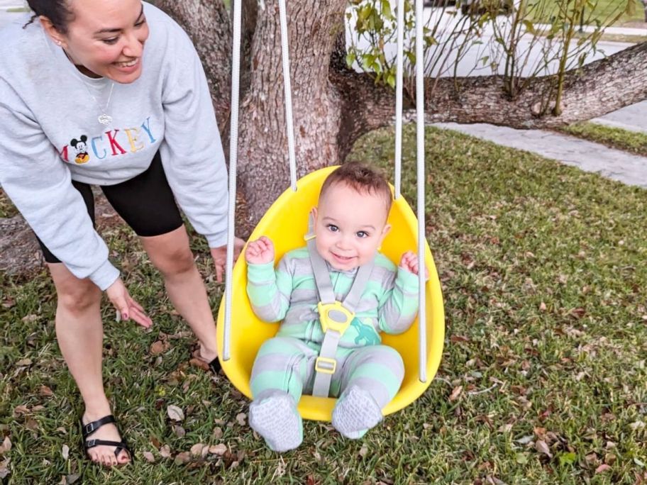 Baby in a yellow Swurfer coconut swing