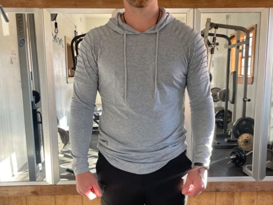 A man wearing a Coffandy Men's Muscle Hoodies in gray