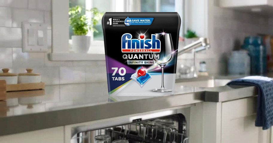 container of Finish Quantum Infinity Shine Dishwasher Pods on kitchen counter above dishwasher