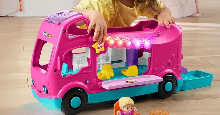 girl playing with Fisher-Price Little People Little Dreamcamper RV Playset