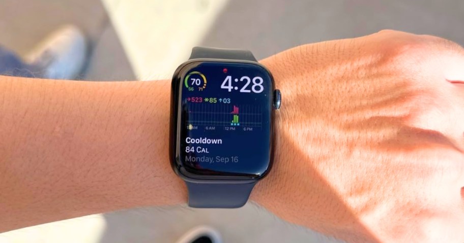 man wearing an Apple watch, showing the time, and fitness info