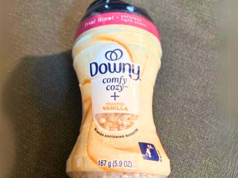 trial size bottle of Downy onlinefy Cozy In-Wash Scent Booster Beads, Toasted Vanilla laying on the floor