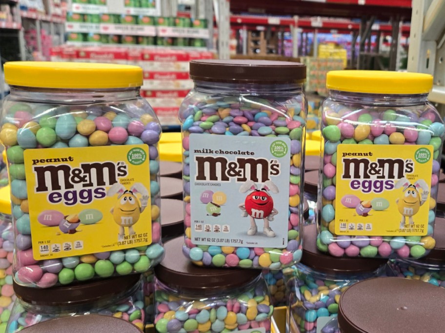 Hand holding M&M'S Peanut Chocolate Pastel Easter Candy 62oz Bulk Jar