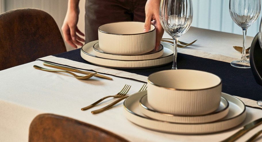 Hand holding thyme and time plates displayed on a table