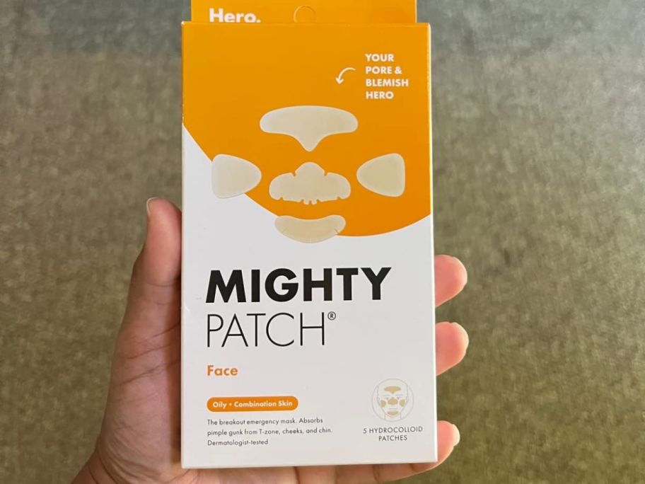 A person holding a Hero Mighty Patch Face box