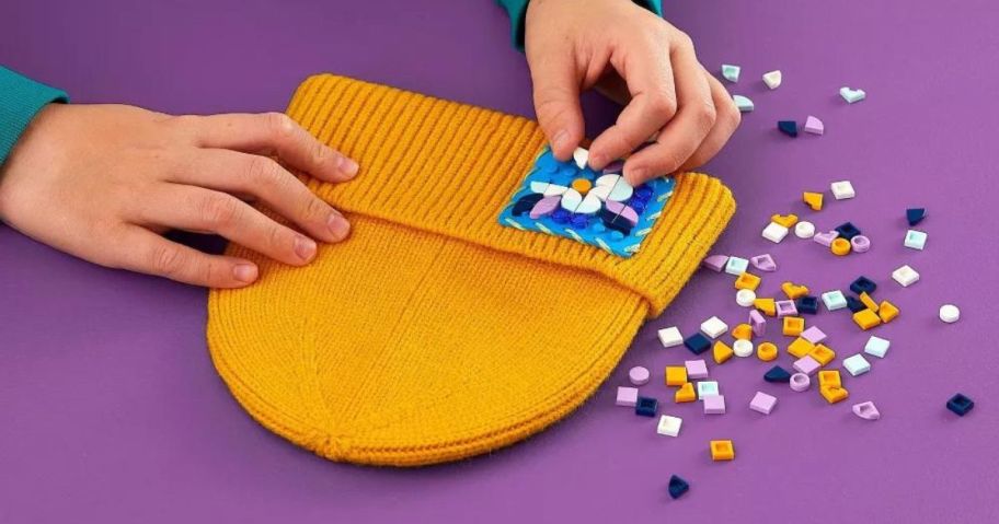 A child attaching a LEGO patch to a hat