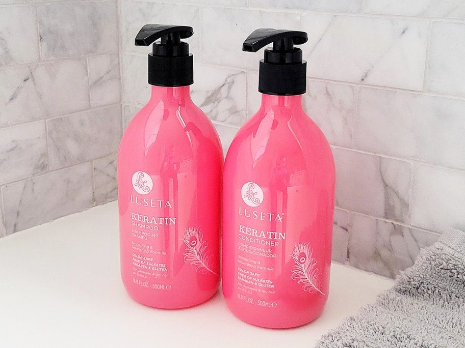 pink luseta keratin shampoo and conditioner bottles in shower