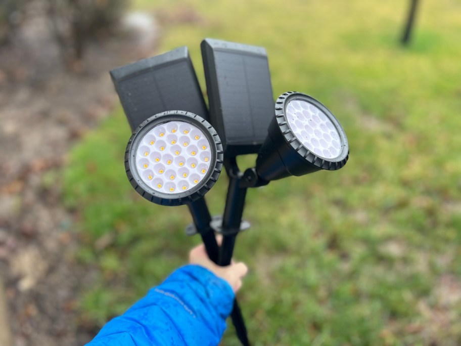 hand holding 2 solar powered spotlights