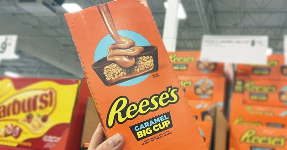 hand holding a large box of Reese's Big Cup Caramel Peanut Butter Cups in store