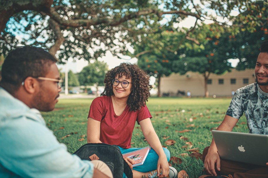 students sitting on a school lawn