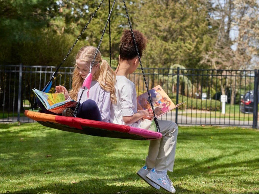 two kids in tree swing reading books